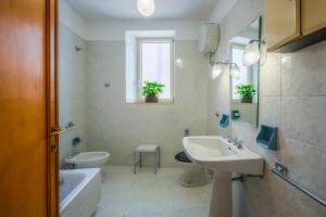 ein Badezimmer mit Waschbecken, Toilette und Spiegel in der Unterkunft Palazzo Perez in Belvedere Marittimo + 32 Fotos