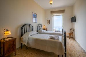 ein Schlafzimmer mit zwei Betten und einem Fenster in der Unterkunft Palazzo Perez in Belvedere Marittimo