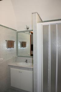 a white bathroom with a sink and a shower at Iaia Apartment in Sciacca