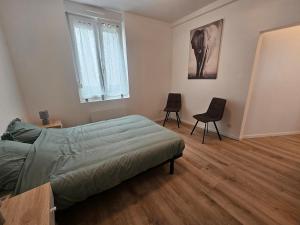 a bedroom with a bed and two chairs in it at 3-room apartment 2b in Thionville