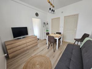 a living room with a tv and a table and chairs at 3-room apartment 2b in Thionville