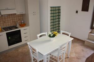 cocina con mesa blanca y sillas blancas en Iaia Apartment, en Sciacca