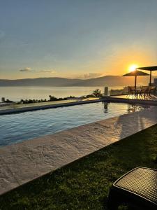 a swimming pool with the sunset in the background at Vistas del Angel in San Juan Cosalá