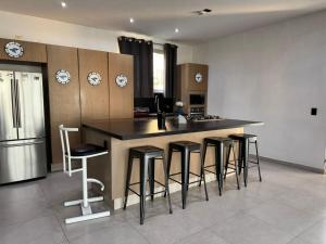 a kitchen with a island with bar stools at Vistas del Angel in San Juan Cosalá