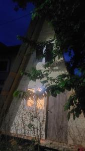 a white building with a window at night at Ada chalet in Mărăcineni