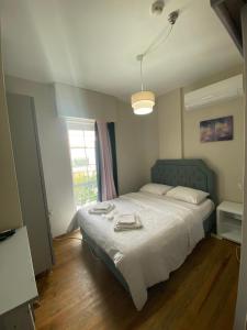 a bedroom with a bed with white sheets and a window at Balim Sultany in Çeşme +157 photos
