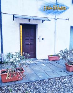 a front door of a white building with potted plants at Il Mulin Dell'Architetto in Fornaci di Barga