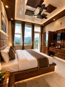 a bedroom with a large bed with a large window at Hotel Himalayan Heaven - A Most Luxury & Best Mountain View Hotel In Mussoorie By lilly in Mussoorie