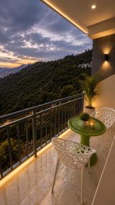 a patio with a table and chairs on a balcony at Hotel Himalayan Heaven - A Most Luxury & Best Mountain View Hotel In Mussoorie By lilly in Mussoorie
