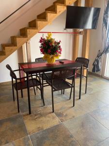 a dining room table with chairs and a vase with flowers at Dimora Filippo in SantʼElpidio a Mare +29 photos