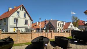 a house and a fence with boats in front of it at HelApart - Mesa in Hel