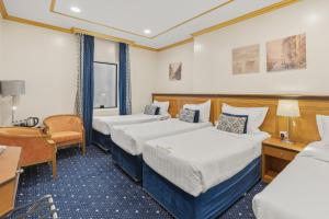 a hotel room with two beds and a desk at Amjad Al Deafah Hotel in Mecca +58 photos