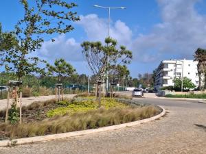 a roundabout on a road with trees and a building at Carcavelos Surf Beach House in Carcavelos +12 photos