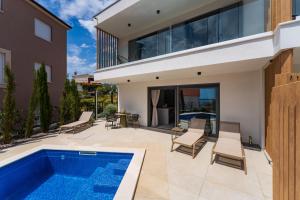 a patio with a swimming pool and a house at Villa Cvita west in Primošten