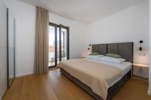 a bedroom with a large bed and a balcony at Villa Cvita west in Primošten