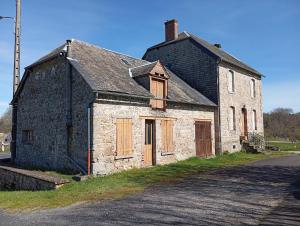 an old stone building on the side of a road at Maison de campagne in Maussac