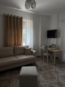 a living room with a couch and a table at Sea You Soon Apartment in Shëngjin