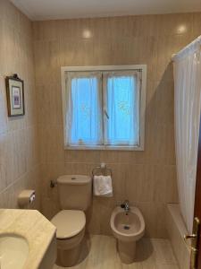 a bathroom with a toilet and a sink and a window at El Ancla in Laredo +18 photos