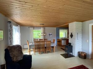 a dining room and living room with a table and chairs at Spacious House with Fjordview in Lauvstad +17 photos