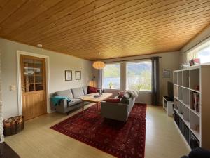 a living room with a couch and a table at Spacious House with Fjordview in Lauvstad