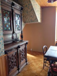 a large wooden cabinet in a room with a table at Maison de campagne in Maussac