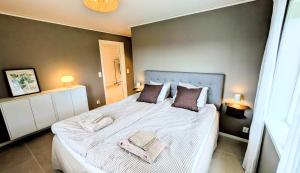 a bedroom with a large bed with two towels on it at Backahöjd Holidays in Rävlanda