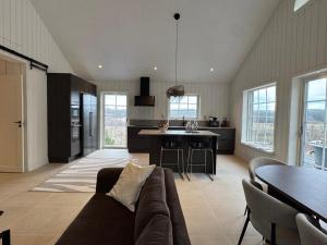 a large living room with a couch and a kitchen at Backahöjd Holidays in Rävlanda