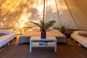 a room with two beds and a vase on a table at Nisi Glamping in Paralia Rachon