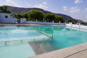 a pool of blue water with mountains in the background at Hotel Raj Resort and Pool in Dogeta
