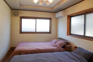 a bedroom with two beds and two windows at 和風グランピング LYS AIBA House 一 わんちゃんと泊まれる一棟貸古民家一Japanese Style Glamping Dog Friendly Private Villa in Takashima