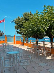 a patio with tables and chairs and the ocean at Fuji Hotel in Edipsos