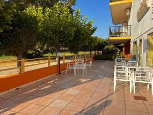 a row of white chairs and tables on a patio at Fuji Hotel in Edipsos