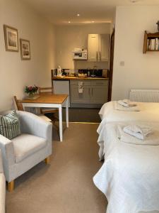 a room with two beds and a table and a kitchen at Church Farm Hartham in Biddlestone +22 photos