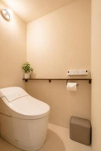 a bathroom with a toilet and a plant on a shelf at OYASUMI Art HOTEL Dotonbori 24-Hour Check-in Pressure-relief mattress in Osaka +90 photos