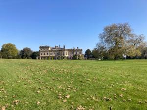 a large house in the middle of a field at Church Farm Hartham in Biddlestone