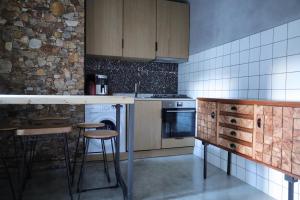 a kitchen with wooden cabinets and a counter with stools at AL Penedo da Cheira in Penacova