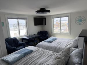 a bedroom with two beds and a desk and two chairs at Salty & Sweet 303 in Old Orchard Beach