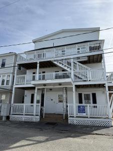 a white house with a balcony on the front of it at Salty & Sweet 303 in Old Orchard Beach