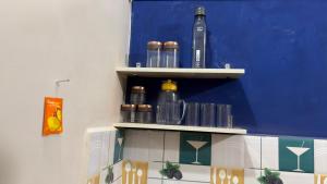 a shelf with glasses and bottles on a wall at The Glory Apartment room 2 in Imphal