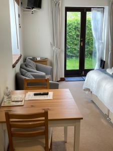 a living room with a table and a bed at Church Farm Hartham in Biddlestone