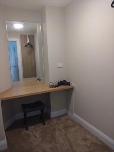 a desk in a room with a mirror and a stool at Codladh Samh Apartment No 2 in Templemore