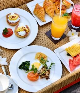 a table with plates of breakfast foods and drinks at Pasir Putih resort & Cafe in Maluk