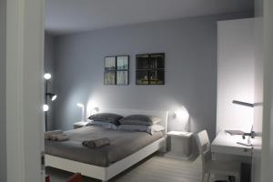 a bedroom with a bed and a desk with two lamps at Le3stanze in Borgomanero