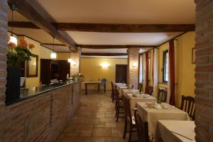 a restaurant with tables and chairs in a room at Hotel Antico Casale in Vigarano Mainarda
