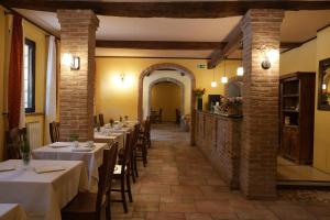 a row of tables in a restaurant with white table cloth at Hotel Antico Casale in Vigarano Mainarda