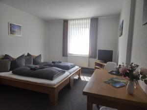 a living room with two beds and a table at Zum Unstrut Radler in Helmsdorf