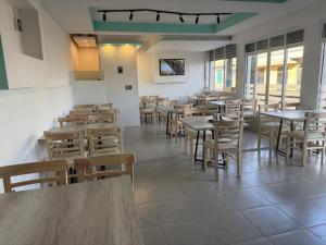 a dining room with tables and chairs and windows at Hotel La Estancia Zacatlan in Zacatlán