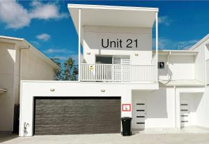 a white building with a garage door in front at 21 Pimpama Home in Pimpama