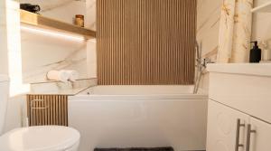 a white bathroom with a toilet and a tub at 40 m2 Confort apartament in Bălţi