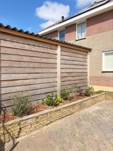 a wooden fence in front of a house at Bed & Beach Zeekraal in De Koog